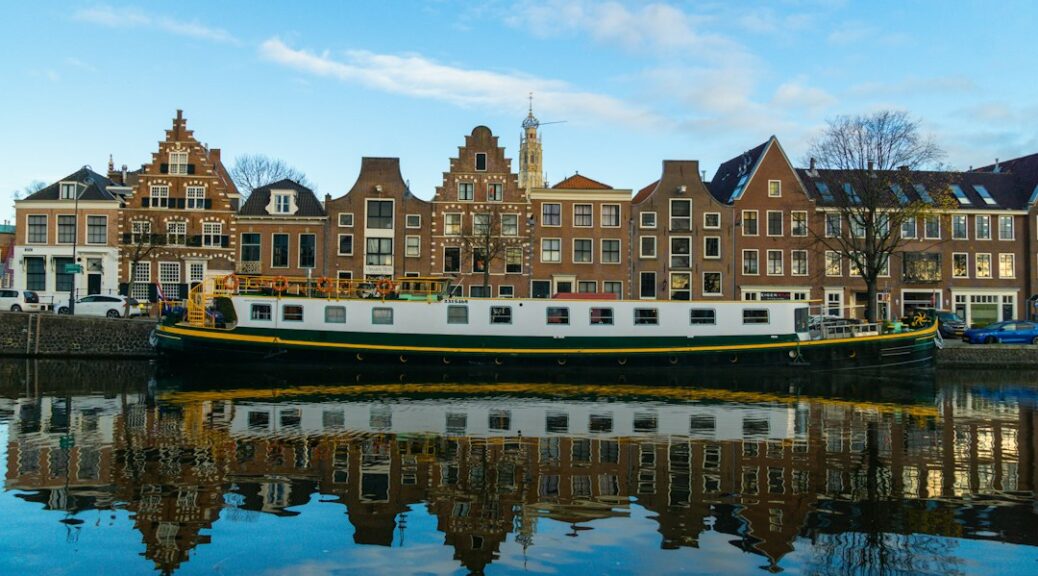 Historische gevels en een boot aan het water in Haarlem