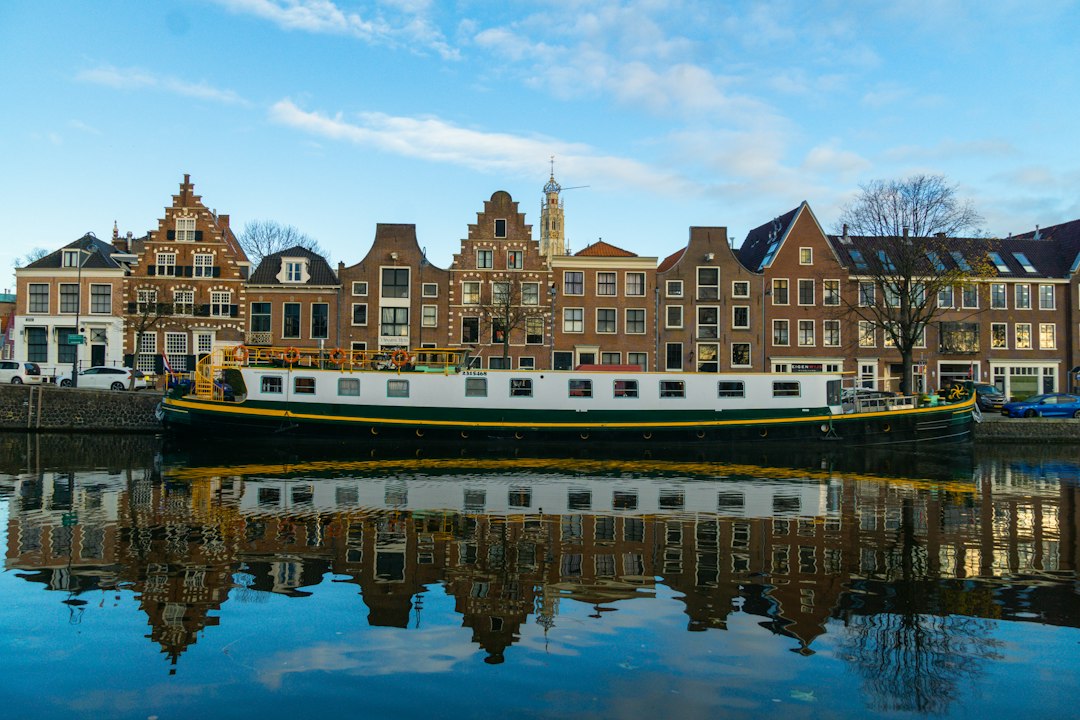 Historische gevels en een boot aan het water in Haarlem