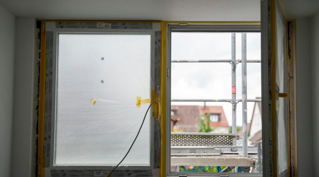 Raam met beschermfolie tijdens een renovatie